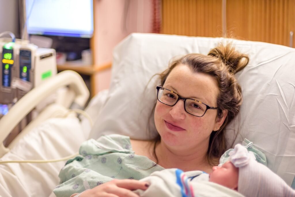 New mom holding first baby in hospital labor and delivery room