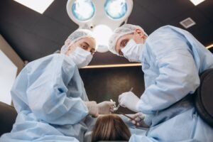 Surgeon performing cosmetic surgery on breasts in hospital operating room.