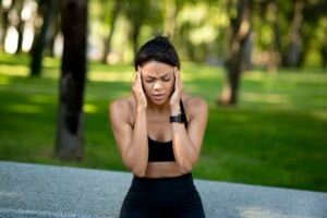 Black woman jogger having headache during training at park