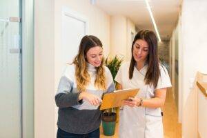 Professional doctor consulting patient in clinic hallway
